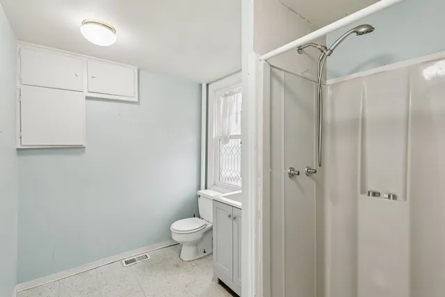 a bathroom with a toilet and a shower