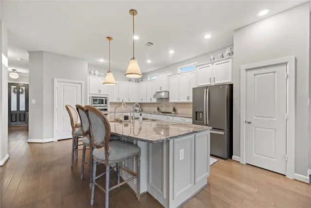 a large kitchen with a table and chairs