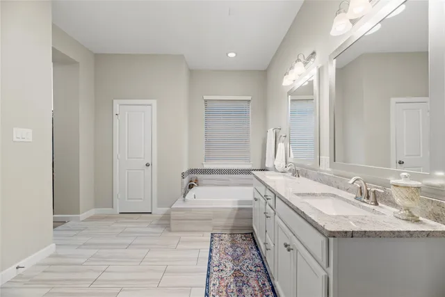 a bathroom with a granite countertop double vanity sink and a mirror