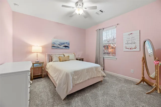 a bedroom with a bed a chandelier and a window