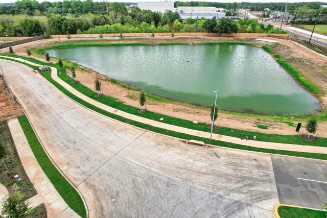 a view of a lake with a yard and large trees