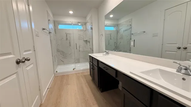 a spacious bathroom with a shower sink and a mirror