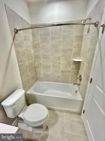 a white toilet sitting next to a bath tub and a shower