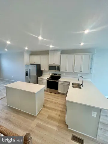 a kitchen with sink a microwave and refrigerator
