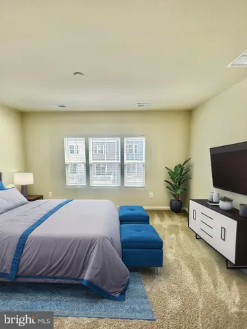 a bedroom with a bed a window and a flat screen television
