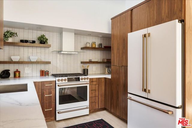 a kitchen with stainless steel appliances a stove a refrigerator and cabinets