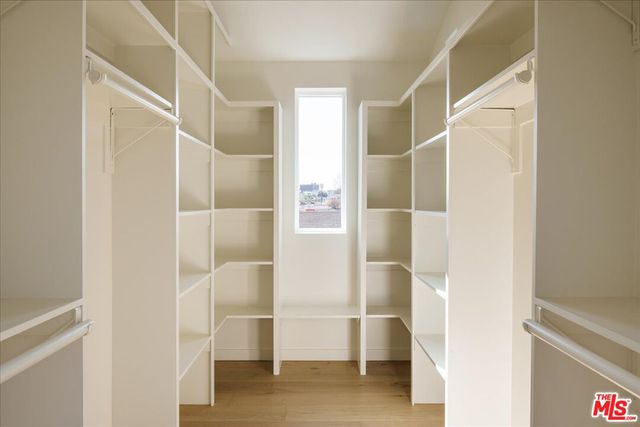 a view of walk in closet with empty racks