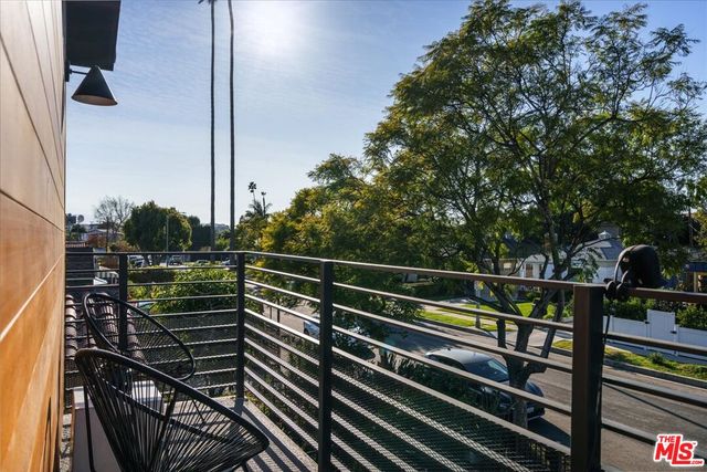 a view of a balcony with two chairs and a potted plant on a table