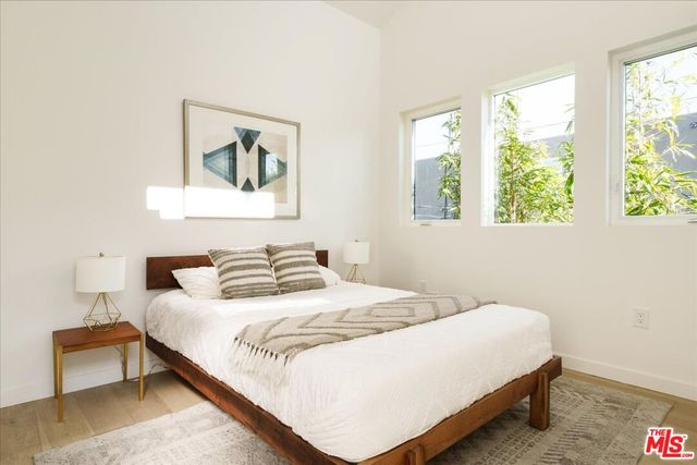 a bedroom with a bed and a painting on the wall