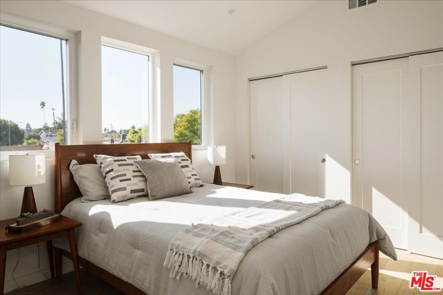 a bedroom with a large bed and a window with the outer view