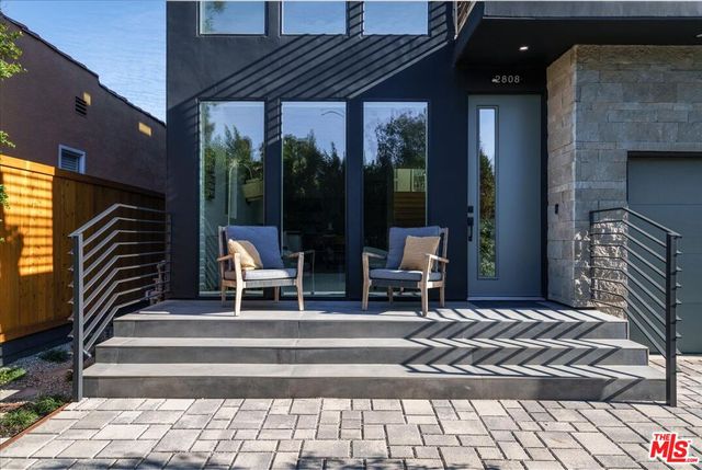 a building outdoor space with patio furniture and potted plants