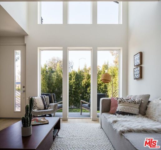 a living room with furniture and a floor to ceiling window