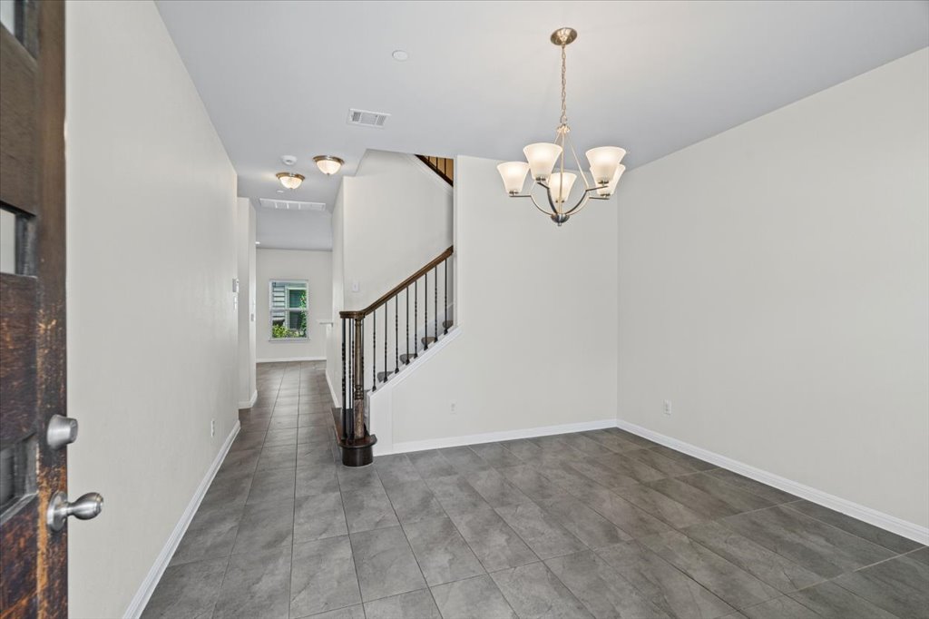 1502 Airedale Road, Unit 2502 Austin, TX 78748 - Photo 4 of 28 A graceful staircase with wrought iron balusters complements the tiled entry and overhead chandelier.