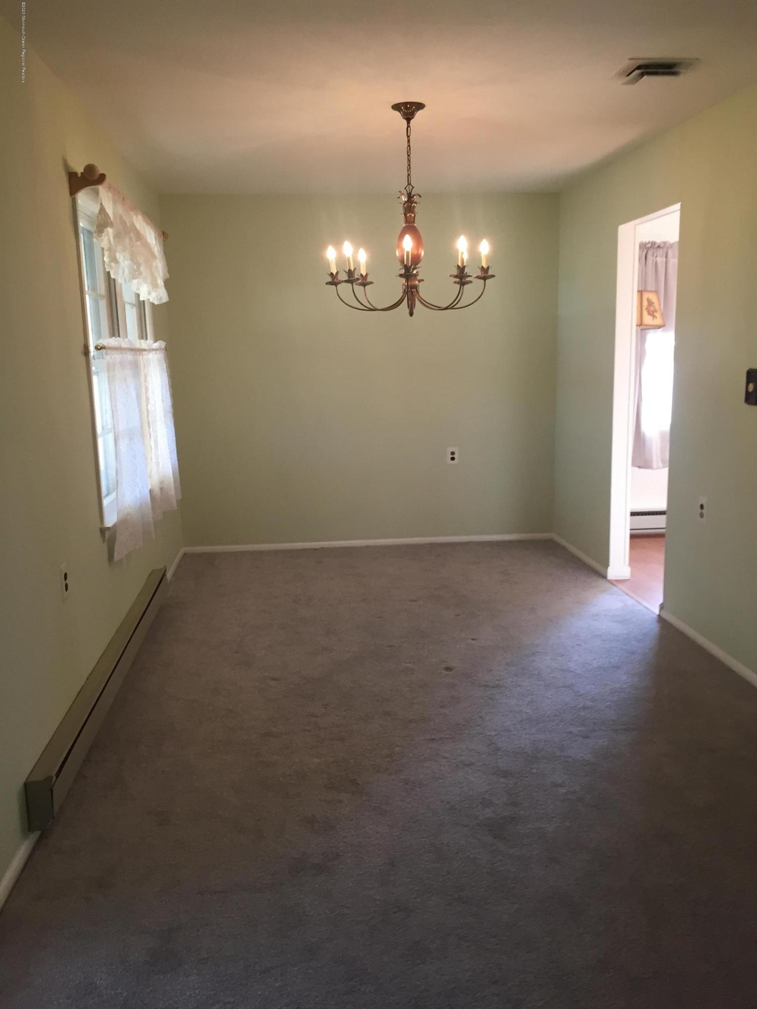 25 Lamb Road Brick, NJ 08724 - Photo 4 of 5 an empty room with chandelier fan and windows