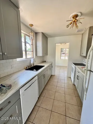 a kitchen with a sink a stove cabinets and a window