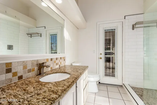 a bathroom with a granite countertop sink and a mirror