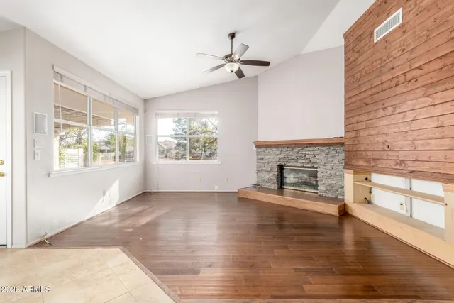 a view of a livingroom with a fireplace wooden floor and windows