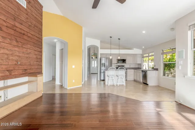 a view of large windows and kitchen with stainless steel appliances