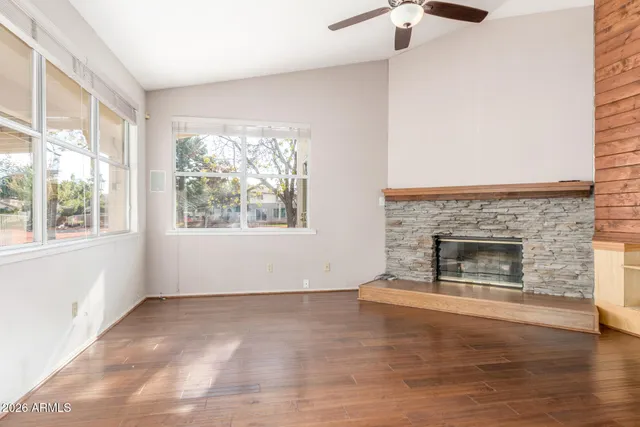 a view of empty room with wooden floor and fireplace