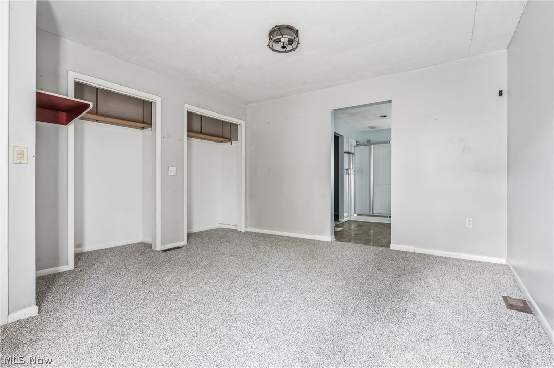 4449 18th Street Northwest Canton, OH 44708 - Photo 12 of 25 Spacious room featuring light gray walls, textured gray carpeting, and a flush-mount ceiling light fixture