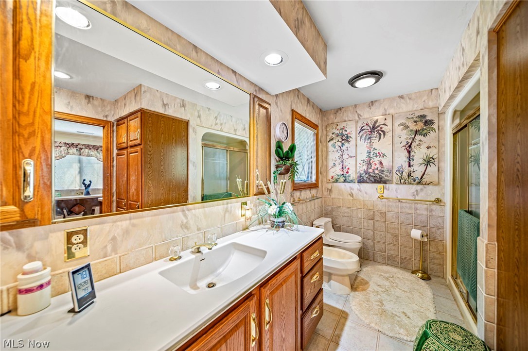 8801 Bunker Road Orwell, OH 44076 - Photo 41 of 50 Full bath with tile walls, vanity, light tile patterned flooring, a shower stall, and a bidet