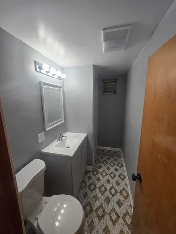 a bathroom with a sink a toilet a mirror and vanity