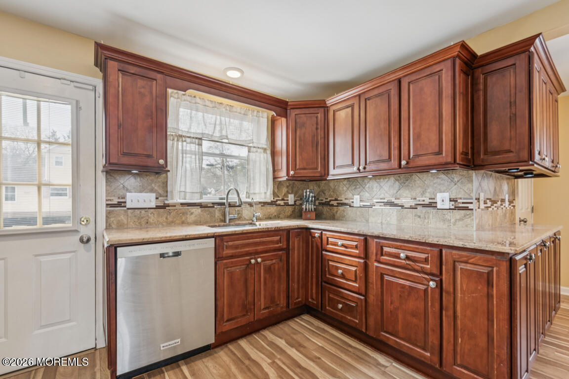 699 Mantoloking Road Brick, NJ 08723 - Photo 16 of 35 a kitchen with stainless steel appliances granite countertop wooden cabinets a sink and dishwasher with wooden floor