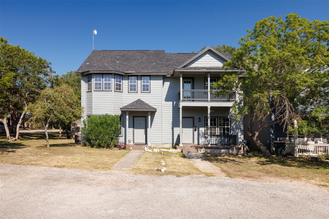 40 Deer Ridge Road Wimberley, TX 78676 - Photo 1 of 1 Traditional-style house featuring a shingled roof, covered porch, and a front lawn