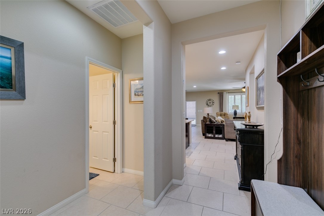 7375 Campbell Ranch Avenue Las Vegas, NV 89179 - Photo 4 of 45 A graceful entry hall opens to the naturally illuminated living area, showcasing crisp tiled flooring throughout main areas.