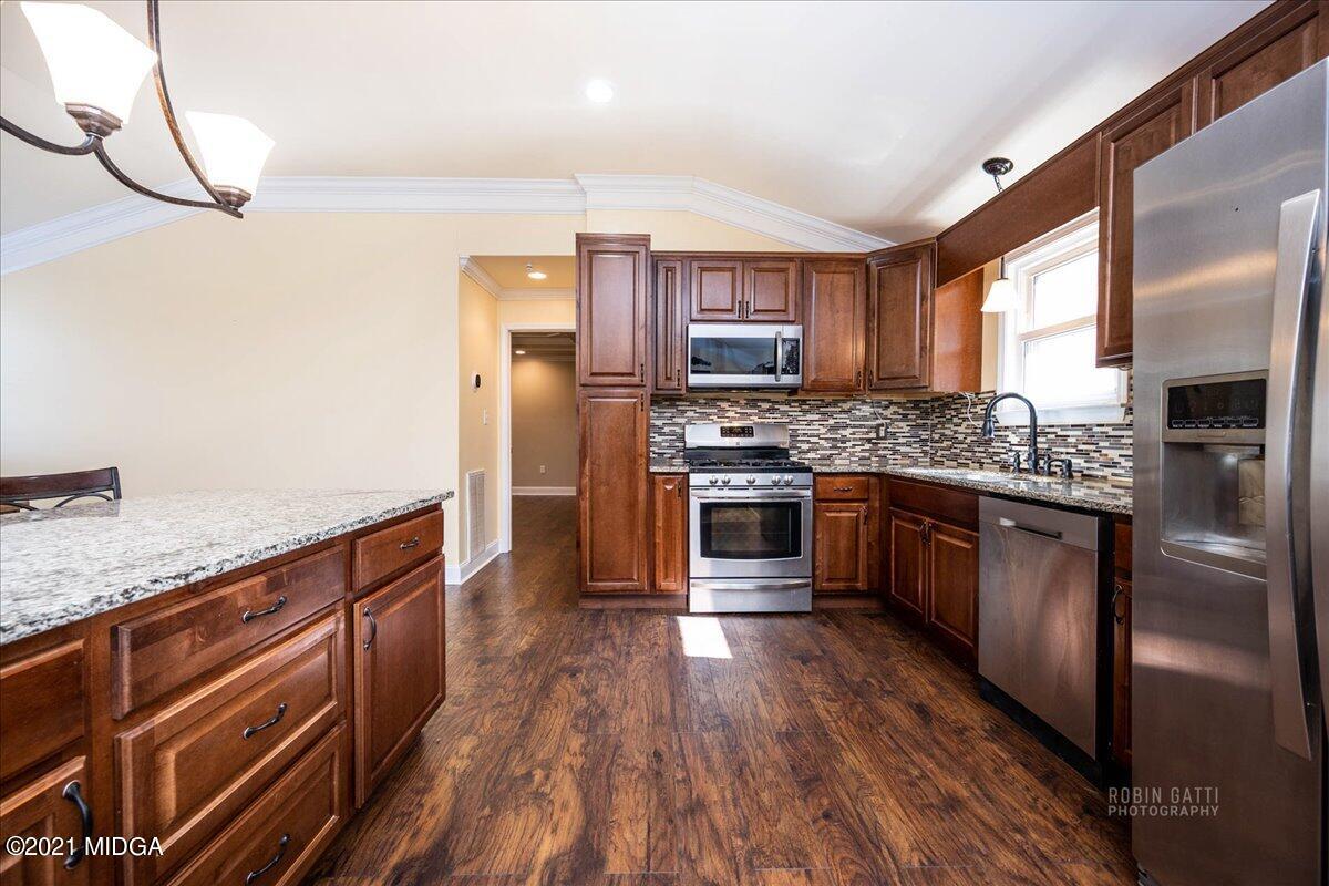 1939 Dames Ferry Road Forsyth, GA 31029 - Photo 2 of 29 a kitchen with stainless steel appliances granite countertop a stove a sink dishwasher a refrigerator and wooden floor