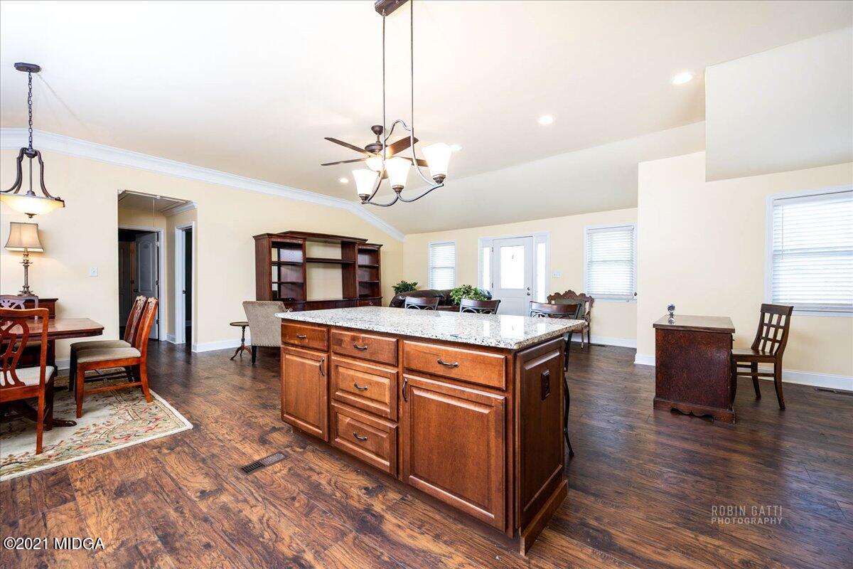 1939 Dames Ferry Road Forsyth, GA 31029 - Photo 4 of 29 a kitchen with stainless steel appliances granite countertop a stove a sink dishwasher a couches with the dining table and chairs