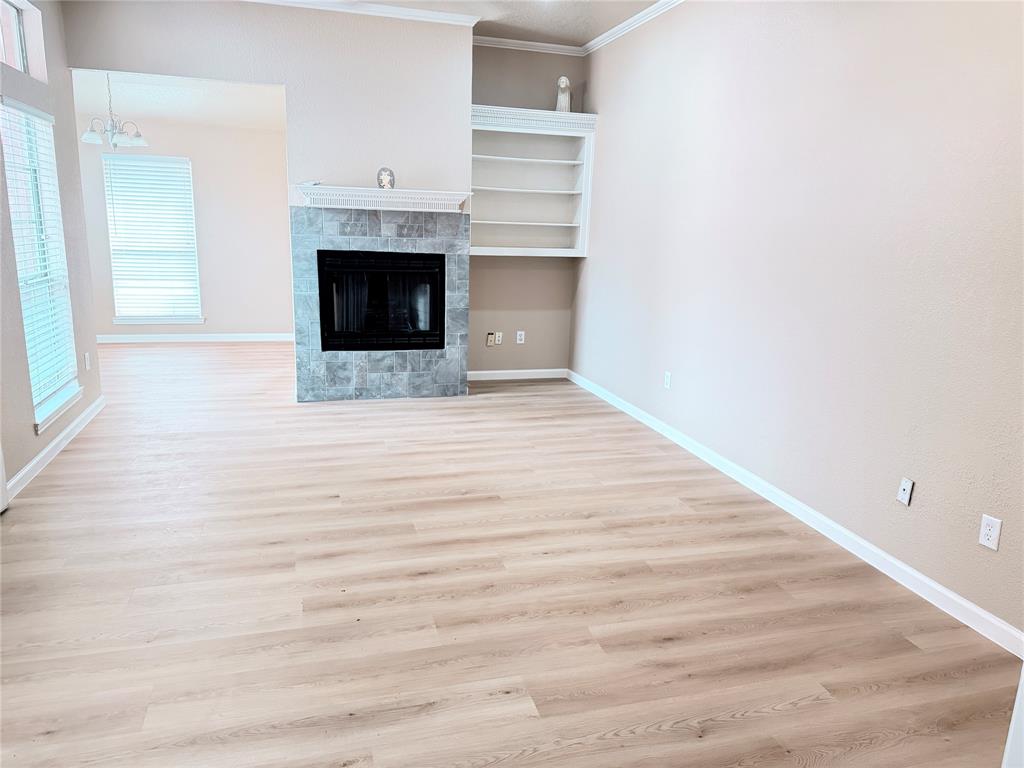 453 Strata Drive Denton, TX 76201 - Photo 3 of 15 a view of an empty room with a fireplace and a window