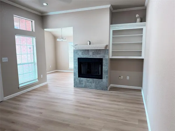a view of empty room with wooden floor and fireplace