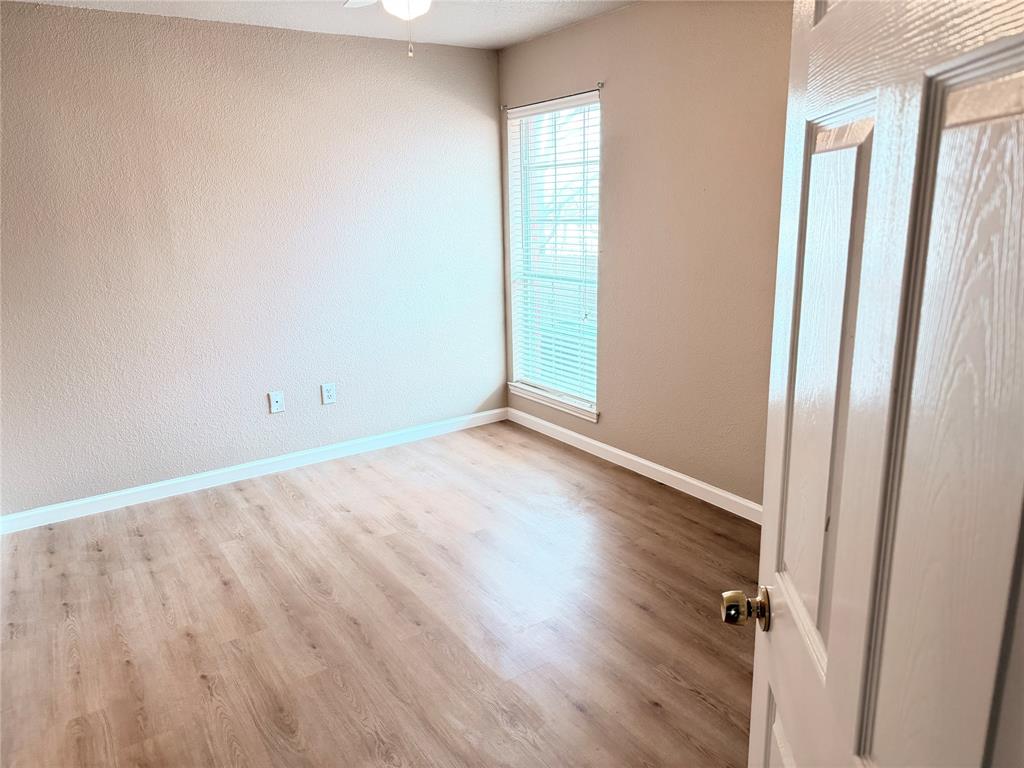 453 Strata Drive Denton, TX 76201 - Photo 9 of 15 an empty room with wooden floor and a window
