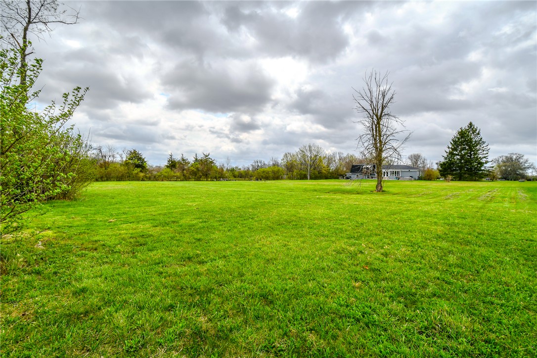 6169 Dayton Farmersville Road Dayton, OH 45417 - Photo 53 of 64 Expansive green yard with ample space for outdoor enjoyment, offering a serene natural setting.