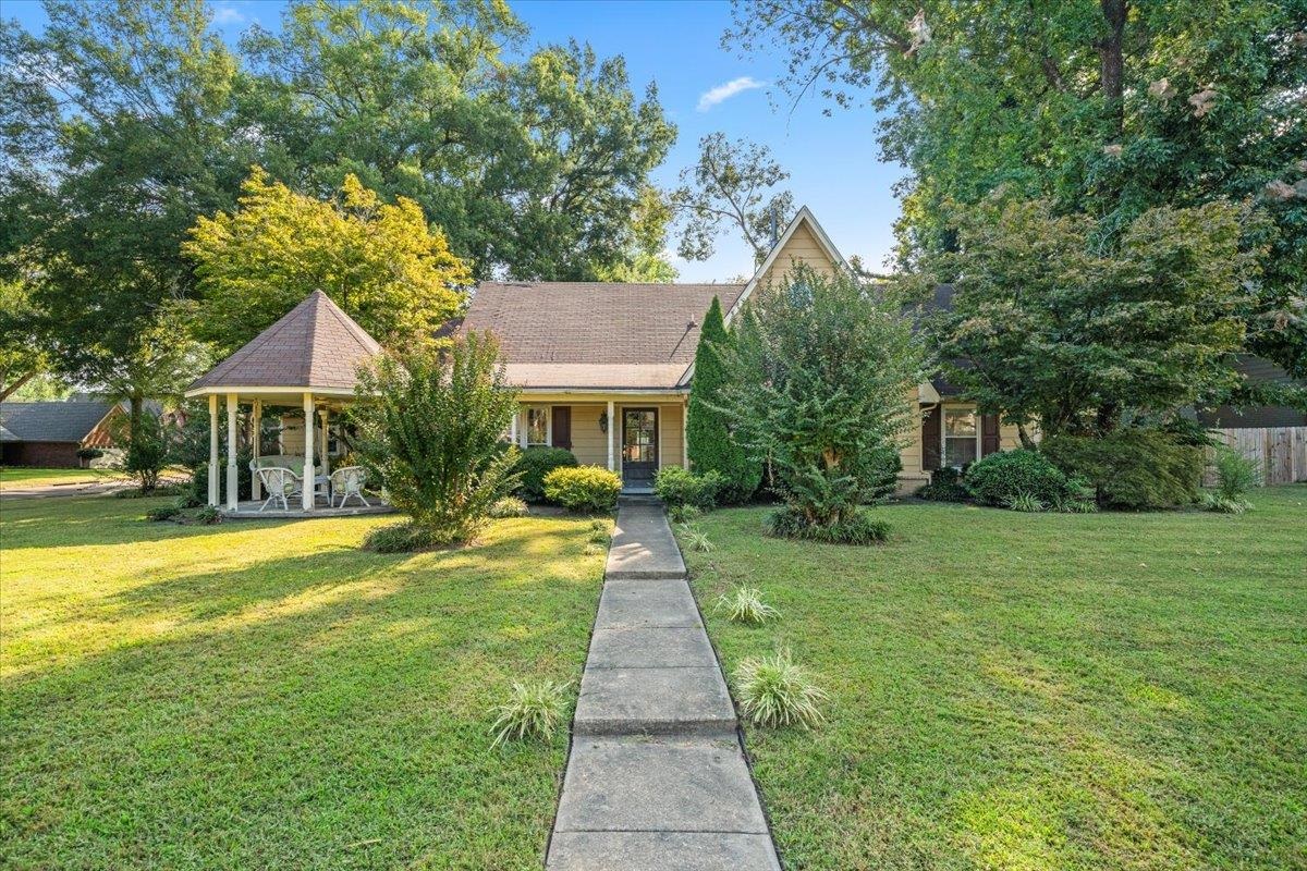a front view of a house with yard and green space