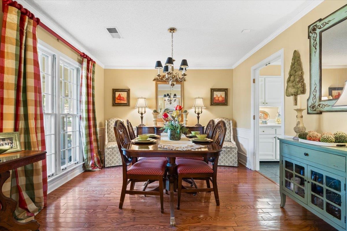 1880 Newfields Road Germantown, TN 38139 - Photo 13 of 34 Dining room with dark wood-style floors, a chandelier, ornamental molding, a textured ceiling, and wainscoting