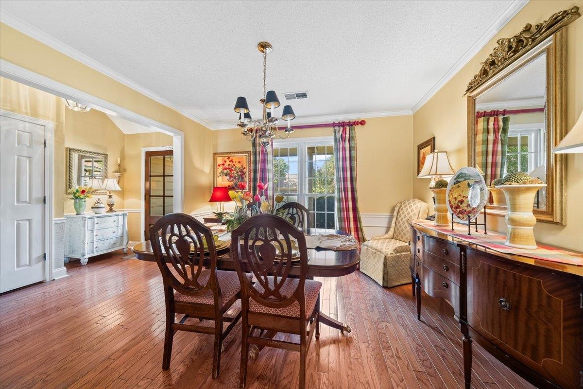 1880 Newfields Road Germantown, TN 38139 - Photo 15 of 34 Dining room with ornamental molding, hardwood / wood-style floors, healthy amount of natural light, a textured ceiling, and a chandelier