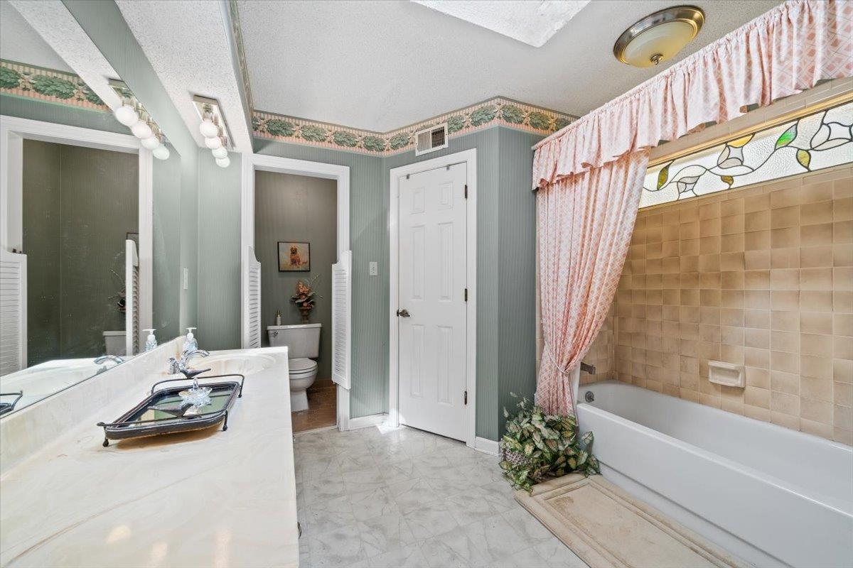 1880 Newfields Road Germantown, TN 38139 - Photo 22 of 34 Full bath with shower / bathtub combination with curtain, vanity, and a textured ceiling