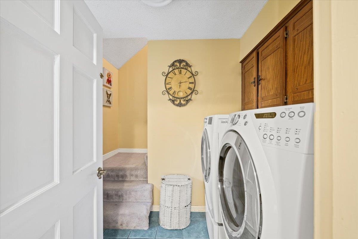 1880 Newfields Road Germantown, TN 38139 - Photo 27 of 34 Laundry area featuring a textured ceiling, tile patterned flooring, separate washer and dryer, and cabinet space
