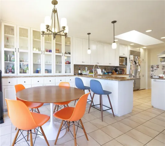 a kitchen with a dining table chairs and white cabinets