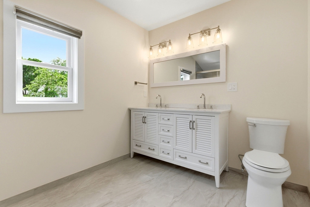 123 Nottinghill Road, Unit 2 Boston, MA 02135 - Photo 12 of 30 a bathroom with a toilet a sink a mirror and a window
