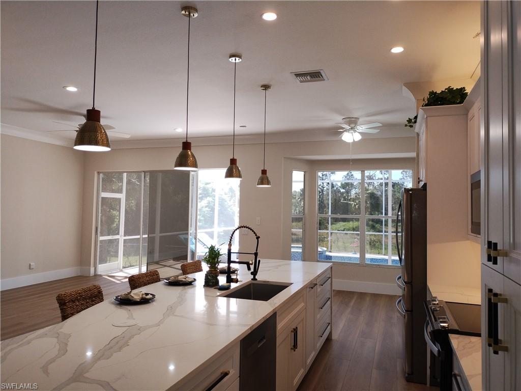 a kitchen with stainless steel appliances a sink a stove and a wooden floor