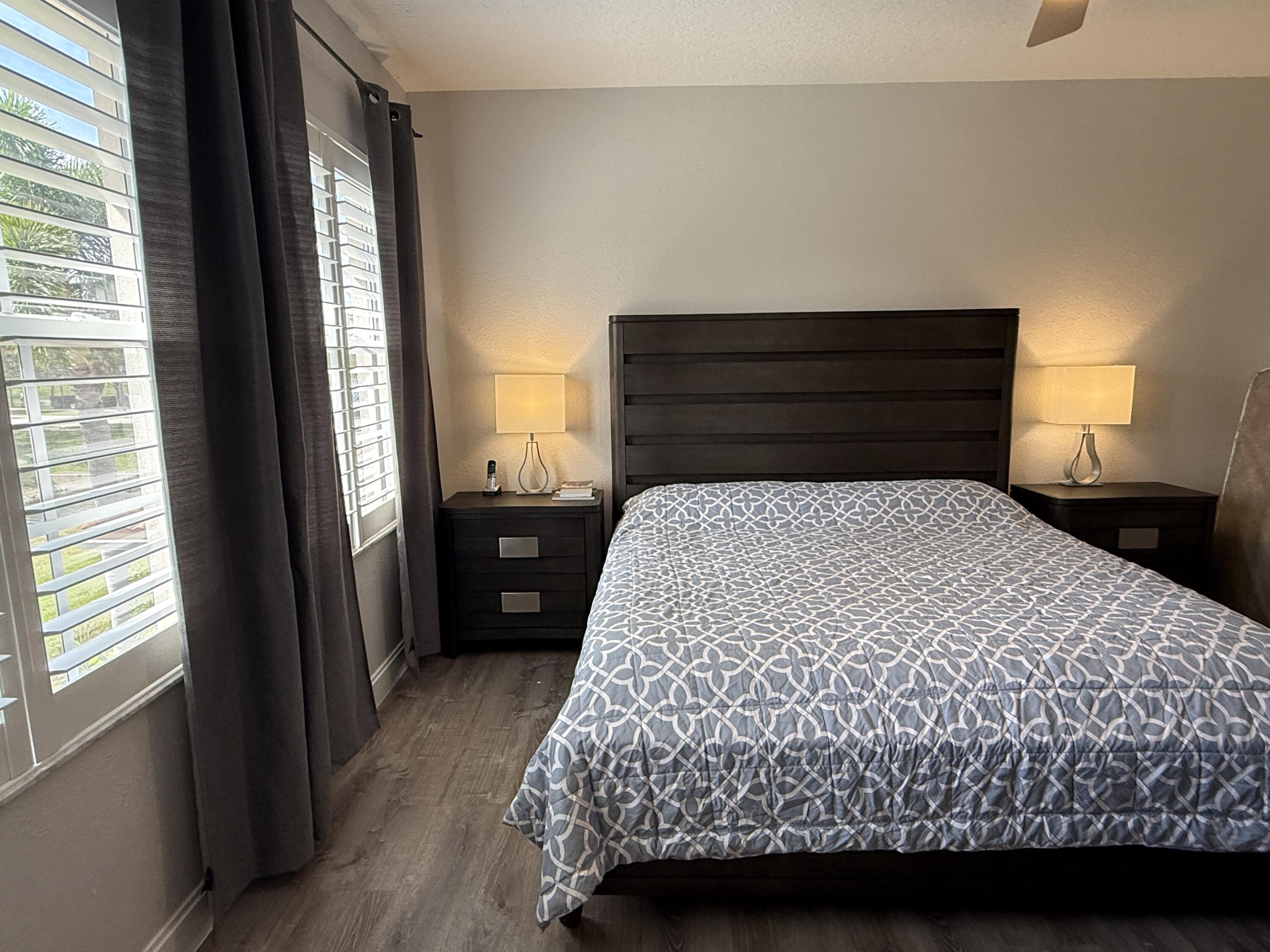 706 Duchess Court Palm Beach Gardens, FL 33410 - Photo 15 of 61 a bed sitting in a bedroom next to a window