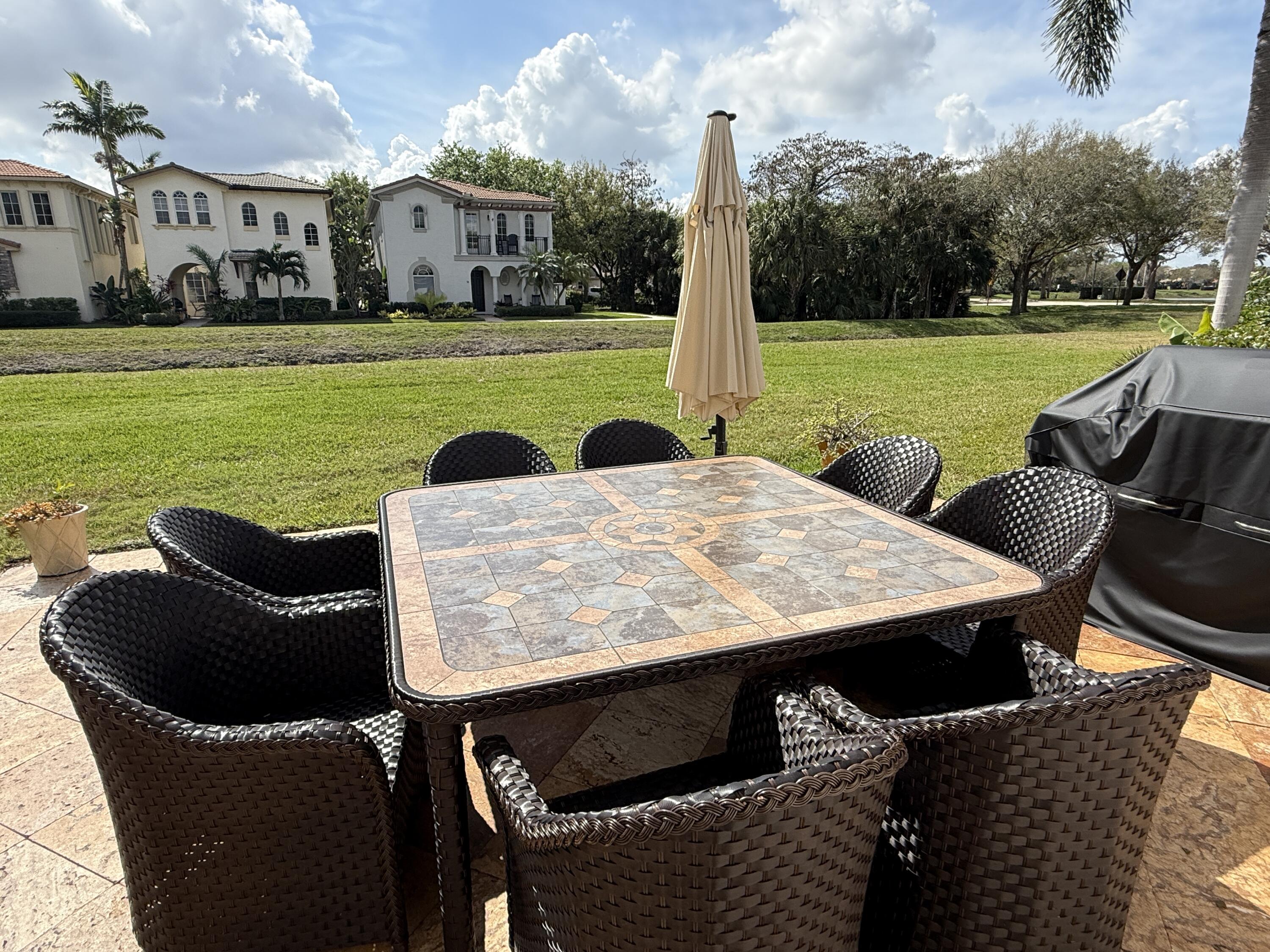 706 Duchess Court Palm Beach Gardens, FL 33410 - Photo 22 of 61 a view of a patio with swimming pool and a yard