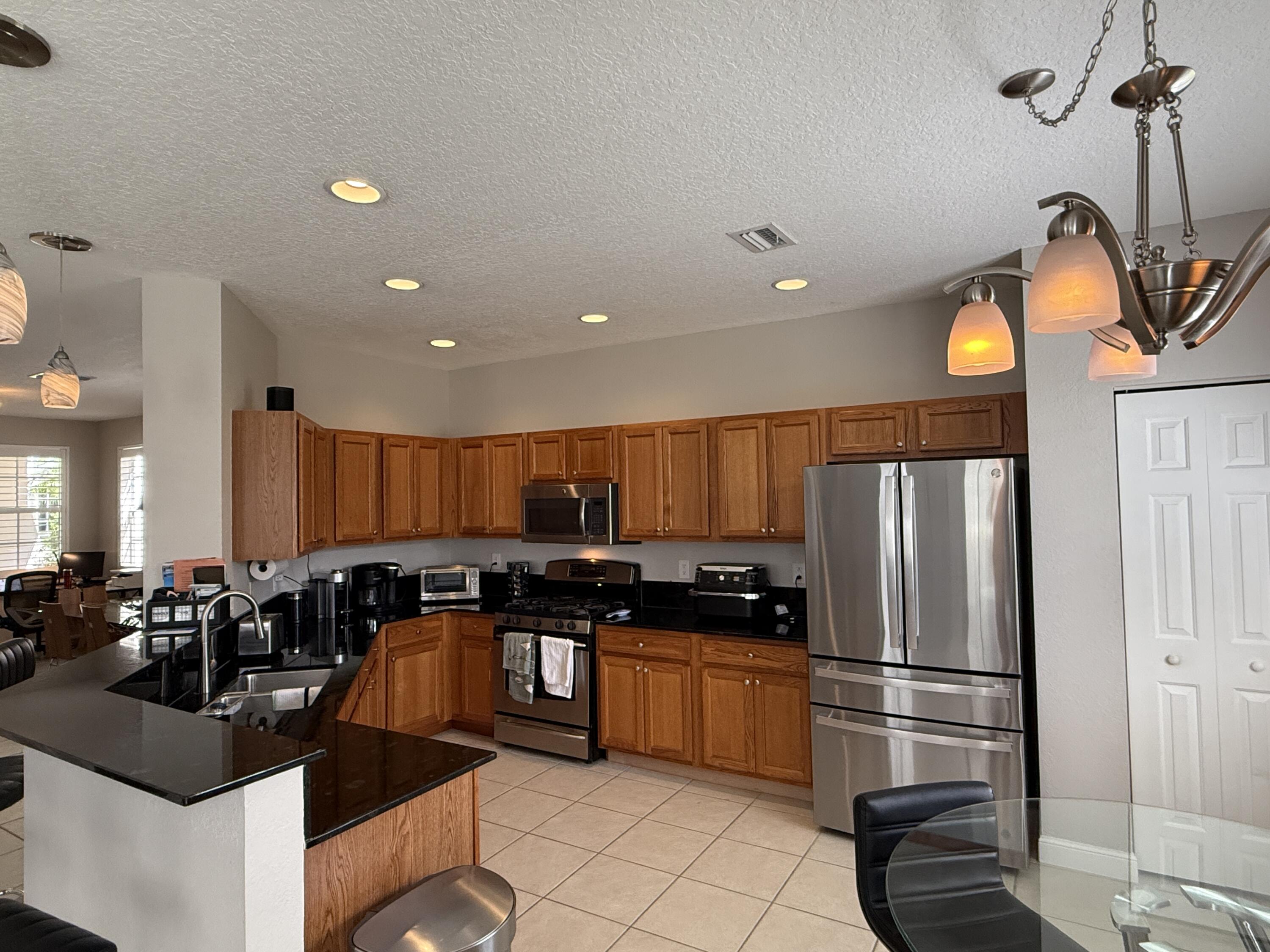 706 Duchess Court Palm Beach Gardens, FL 33410 - Photo 5 of 61 a kitchen with stainless steel appliances a refrigerator a stove a sink and a refrigerator