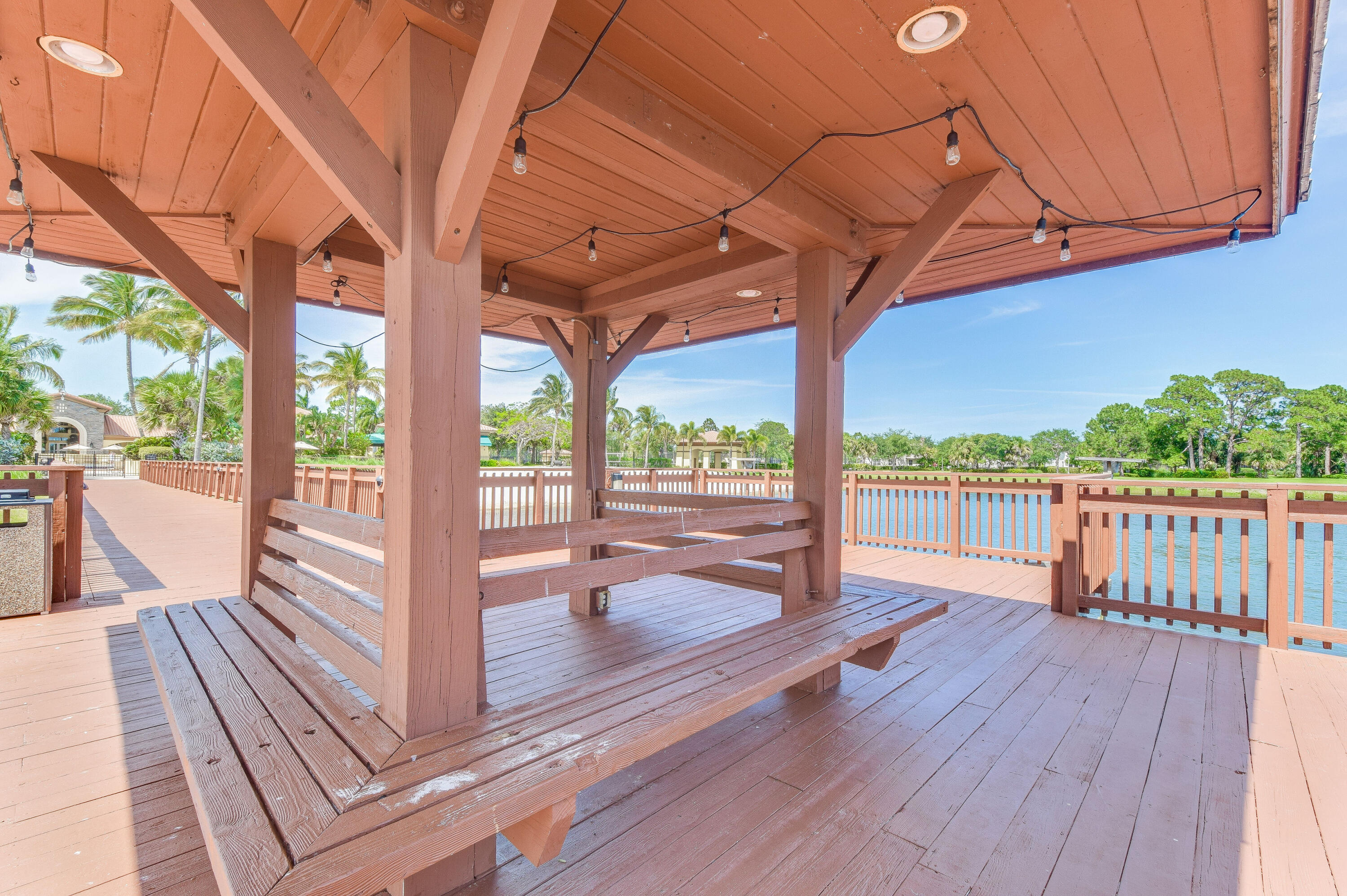 706 Duchess Court Palm Beach Gardens, FL 33410 - Photo 56 of 61 a porch with wooden floor next to a yard