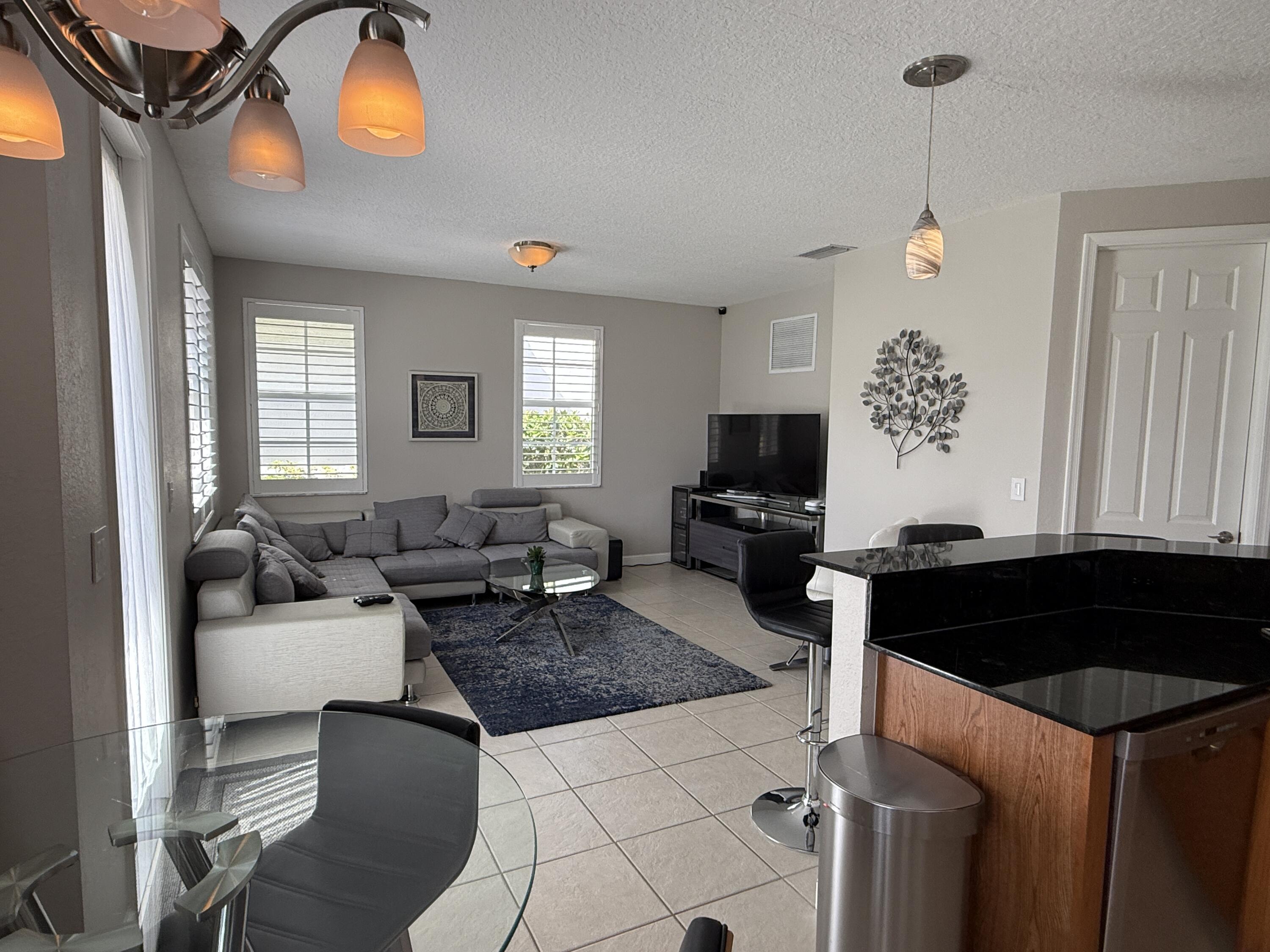706 Duchess Court Palm Beach Gardens, FL 33410 - Photo 8 of 61 a living room with furniture and a flat screen tv