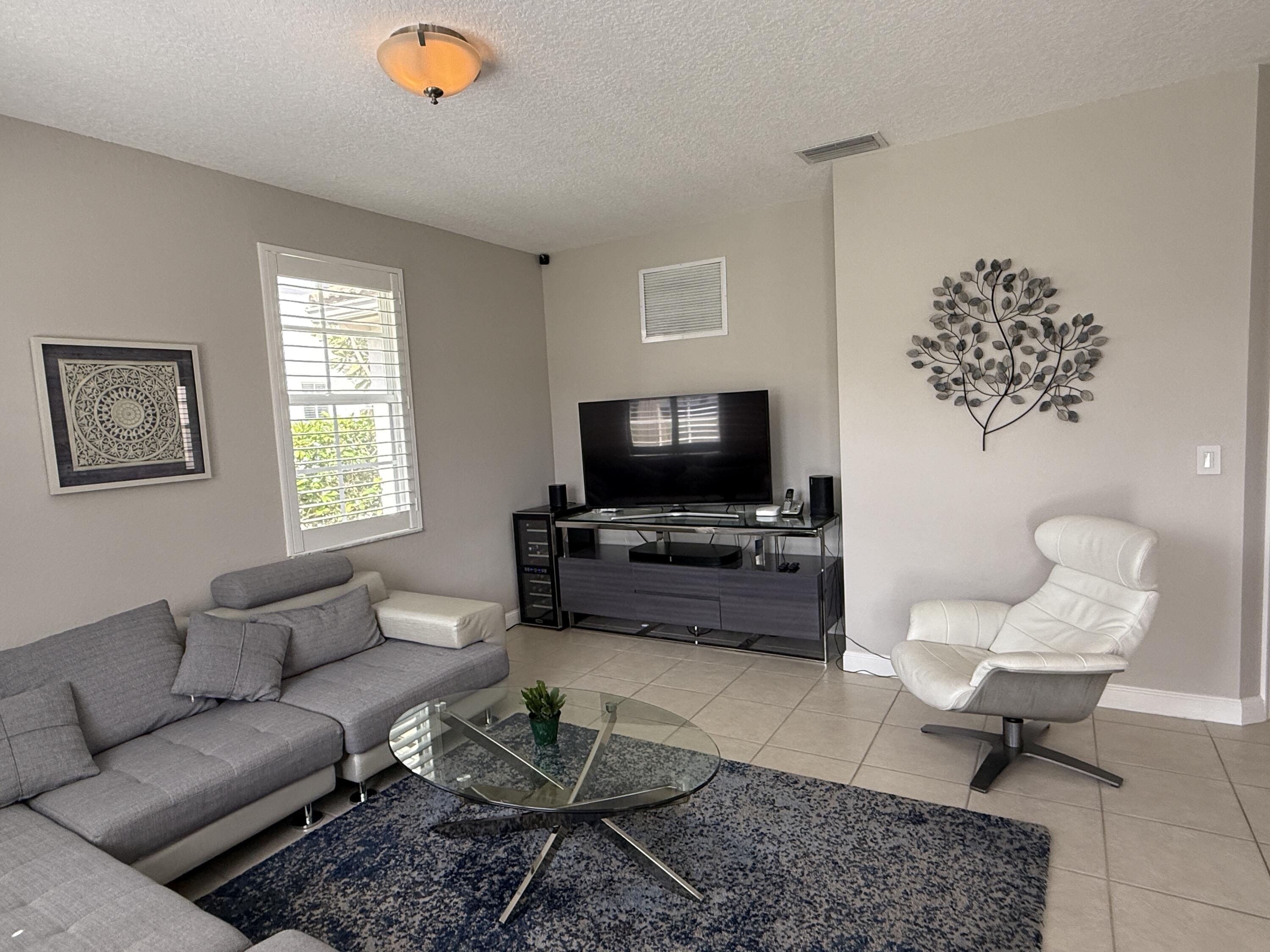 706 Duchess Court Palm Beach Gardens, FL 33410 - Photo 10 of 61 a living room with furniture and a flat screen tv