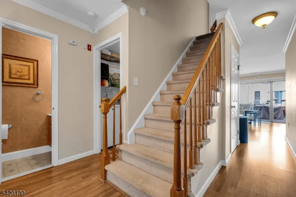 a view of a hallway with wooden floor and staircase